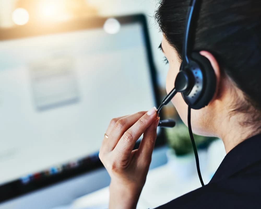 Customer support agent assisting users through a customer web portal on a desktop computer.