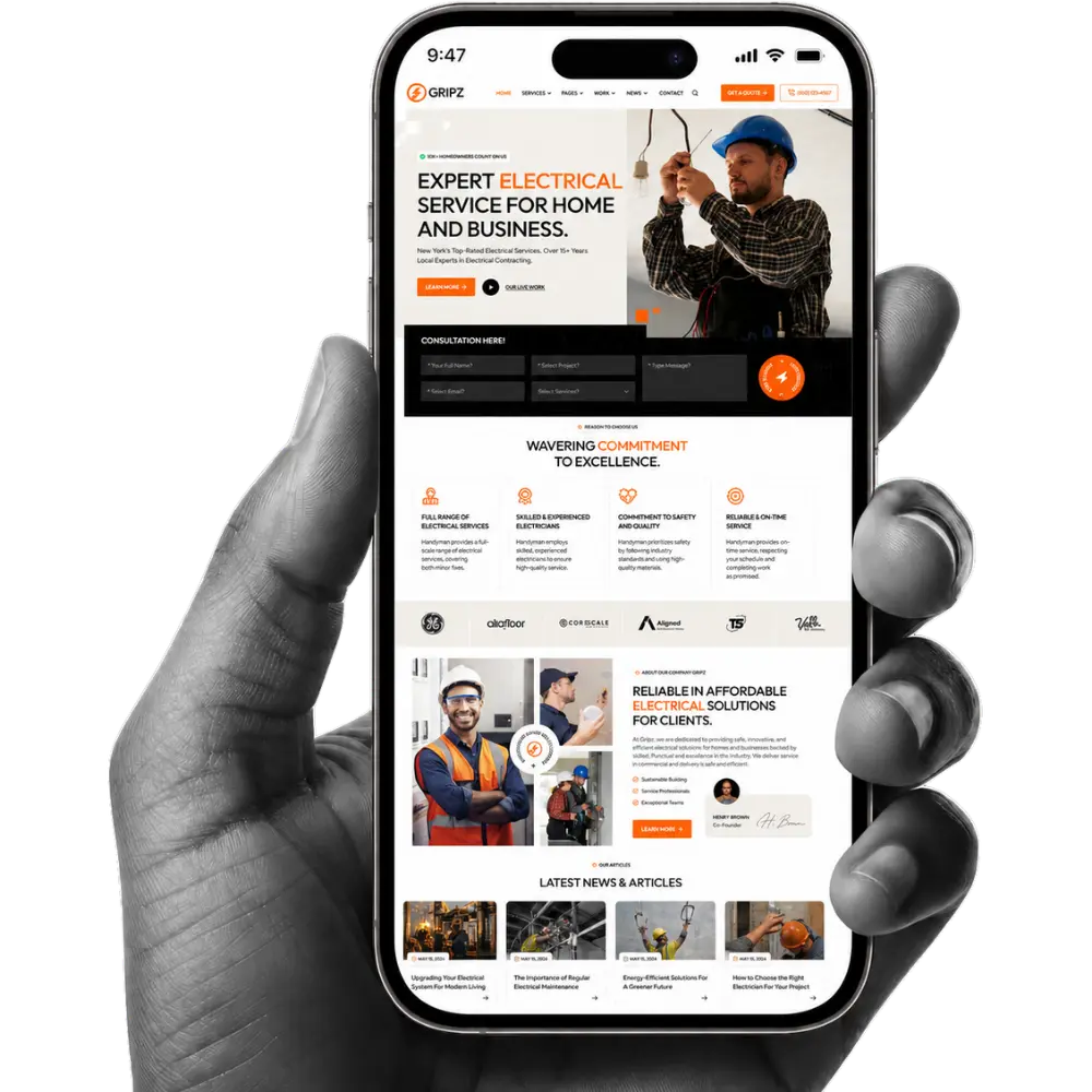 Hand holding a smartphone showing an electrician web design company layout with service forms, electrical project images, trust badges, and CTA buttons.