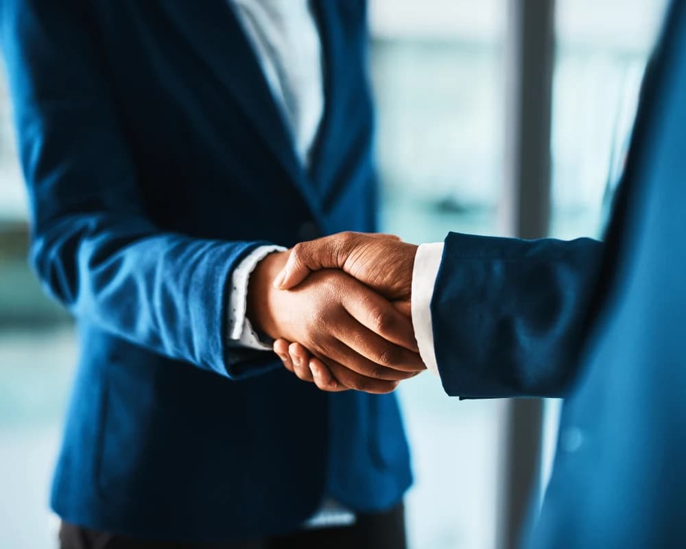 Business partners shaking hands, representing collaboration through partner web portals.