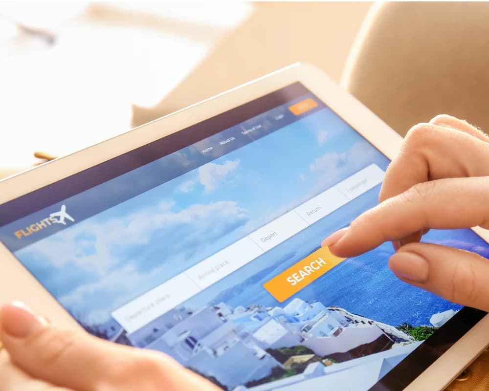 User searching and booking travel services through a self-service web portal on a tablet.